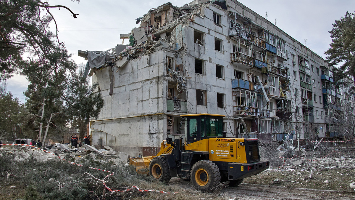 Az éjszakai orosz tüzérségi támadásban megsérült épület romjainál dolgoznak mentők a kelet-ukrajnai Harkivi területen fekvő Csuhuiv közelében lévő Kluhino-Baskirivka 2022. december 2-án.