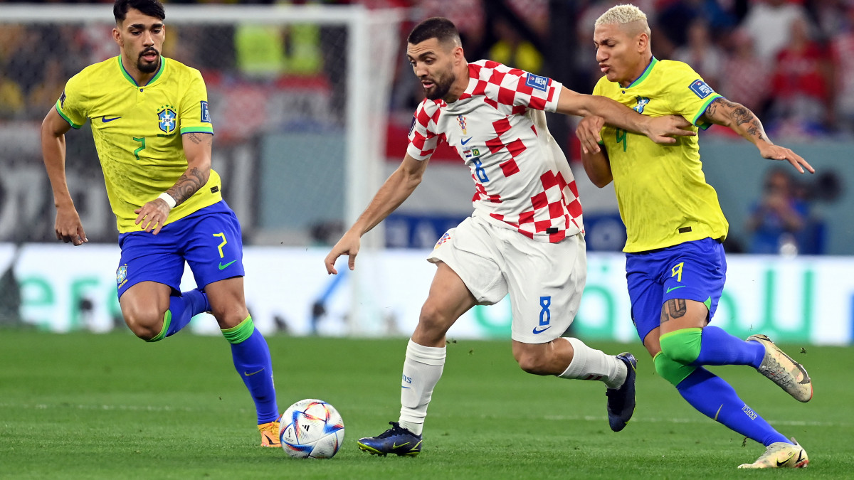 A horvát Mateo Kovacic (k), illetve a brazil Lucas Paqueta (b) és Richarlison a katari labdarúgó-világbajnokság negyeddöntőjében játszott Horvátország-Brazília mérkőzésen az ar-rajjáni Egyetemvárosi Stadionban 2022. december 9-én.
