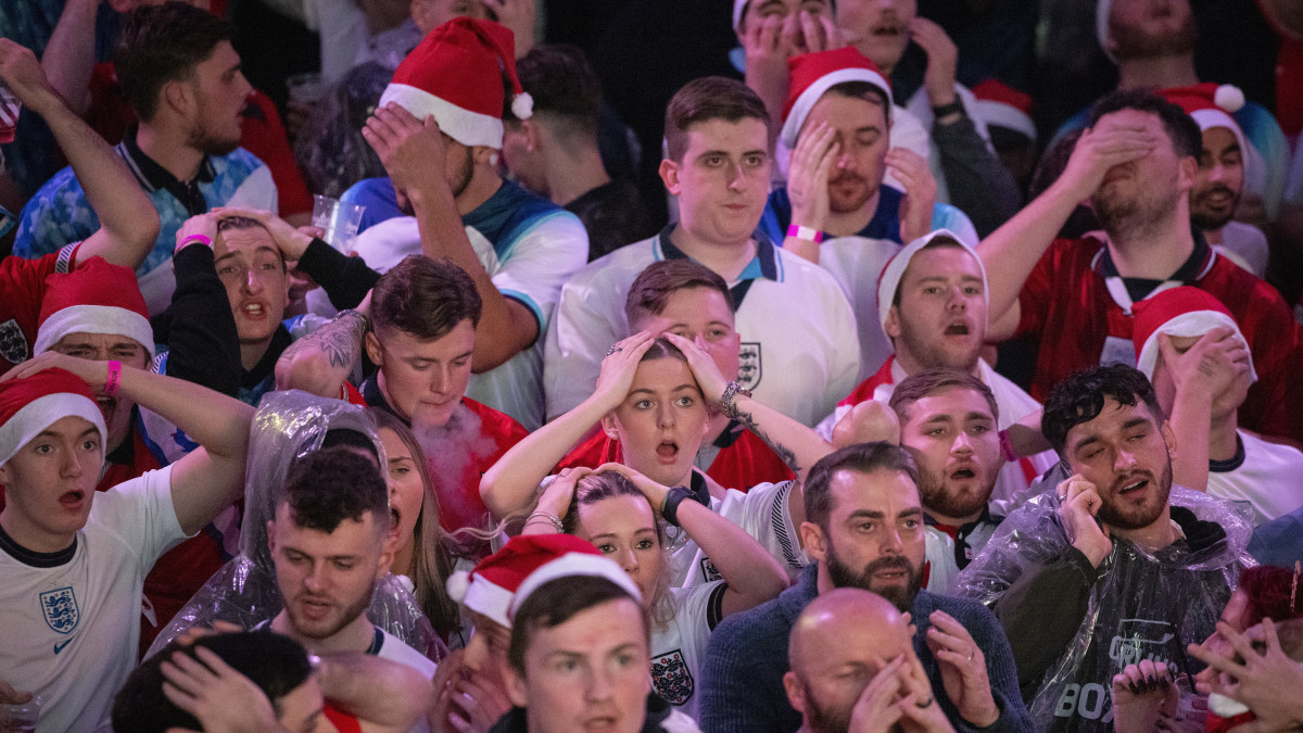 A katari labdarúgó-világbajnokság Anglia-Franciaország negyeddöntő mérkőzésének közvetítését néző angol szurkolók ünnepelnek az angol Harry Kane egyenlítőgólja után a londoni Wembley parkban 2022. december 10-én.