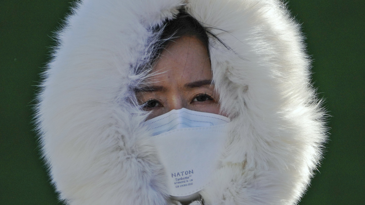 A koronavírus ellen védőmaszkot viselő járókelő Pekingben 2022. december 11-én. A vírusfertőzéses esetek növekvő száma miatt a kínai hatóságok újabb intenzív osztályokat létesítenek és megerősítik a kórházakat.