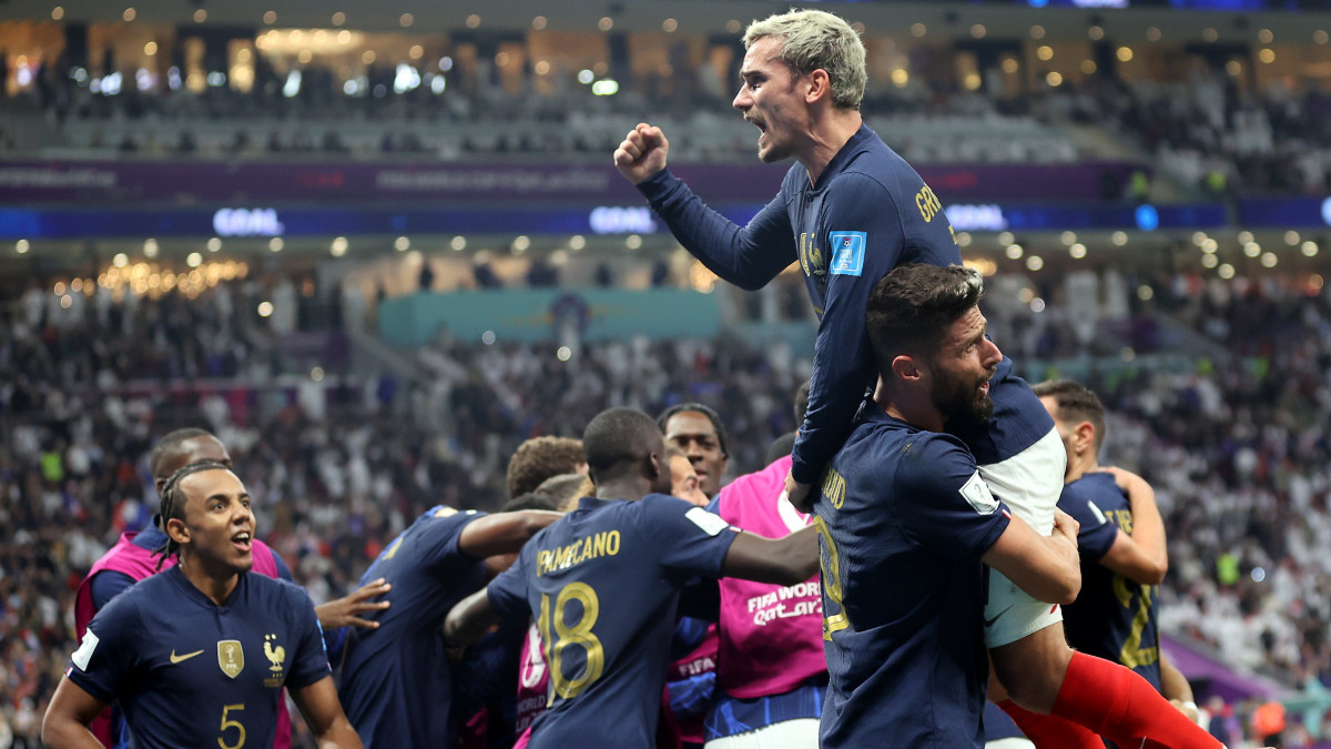 A francia Olivier Giroud (j) csapattársaival ünnepel, miután gólt fejelt a katari labdarúgó-világbajnokság Anglia-Franciaország negyeddöntő mérkőzésén az al-hori al-Bajt Stadionban 2022. december 10-én.