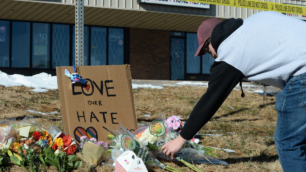 Az áldozatok emlékére virágot tesz le egy férfi a helyszín közlében, Colorado Springsben 2022. november 20-án, miután az éjjel egy 22 éves férfi lőfegyverével tüzet nyitott egy homoszexuálisok látogatta bárban. A támadó öt embert megölt, tizennyolcat megsebesített, mielőtt a vendégek lefegyverezték, majd a rendőrök őrizetbe vették.