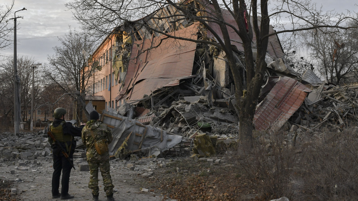 Orosz tüzérségi támadásban megsérült iskolaépület előtt rendőrök a kelet-ukrajnai Donyecki területen fekvő Kramatorszkban 2022. december 22-én.