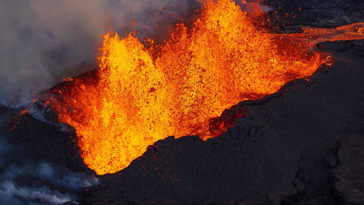 Vörösen izzó lávafolyam ömlik le a világ legnagyobb működő vulkánja, a Mauna Loa Mokuaweoweo kráteréből a hawaii Nagy-szigeten lévő Hilo település közelében 2022. november 30-án, két nappal a tűzhányó kitörése után. A Mauna Loa 38 évvel ezelőtt tört ki utoljára.