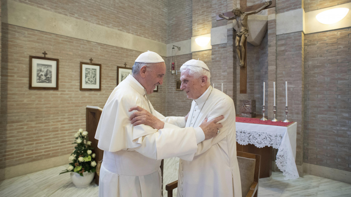 A 2017. június 28-i képen Ferenc pápa (b) és XVI. Benedek emeritus pápa üdvözli egymást a vatikáni Mater Ecclesiae-kolostor kápolnájában. Ferenc pápa 2020. november 28-án bejelentette, hogy a 95 esztendős XVI. Benedek nagyon beteg.