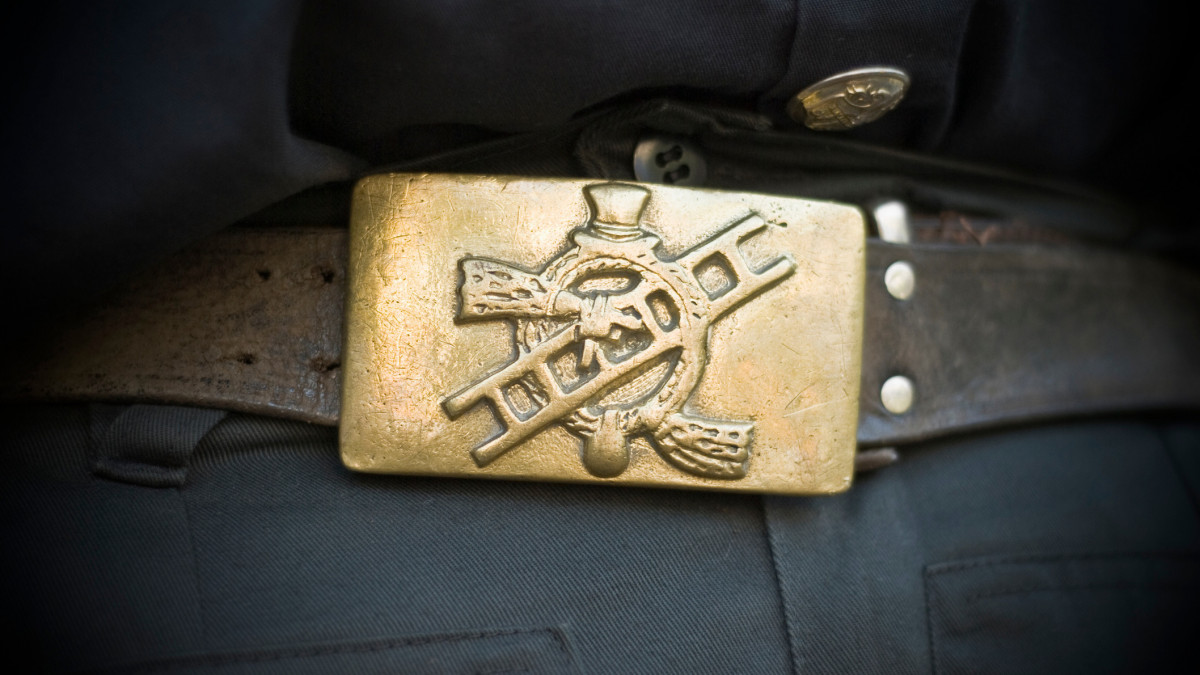 The belt buckle of a chimney sweeps outfit showing the emblem with a ladder, sweep and the obligatory top-hat.The emblem has over 300 years.Dark vignetting added