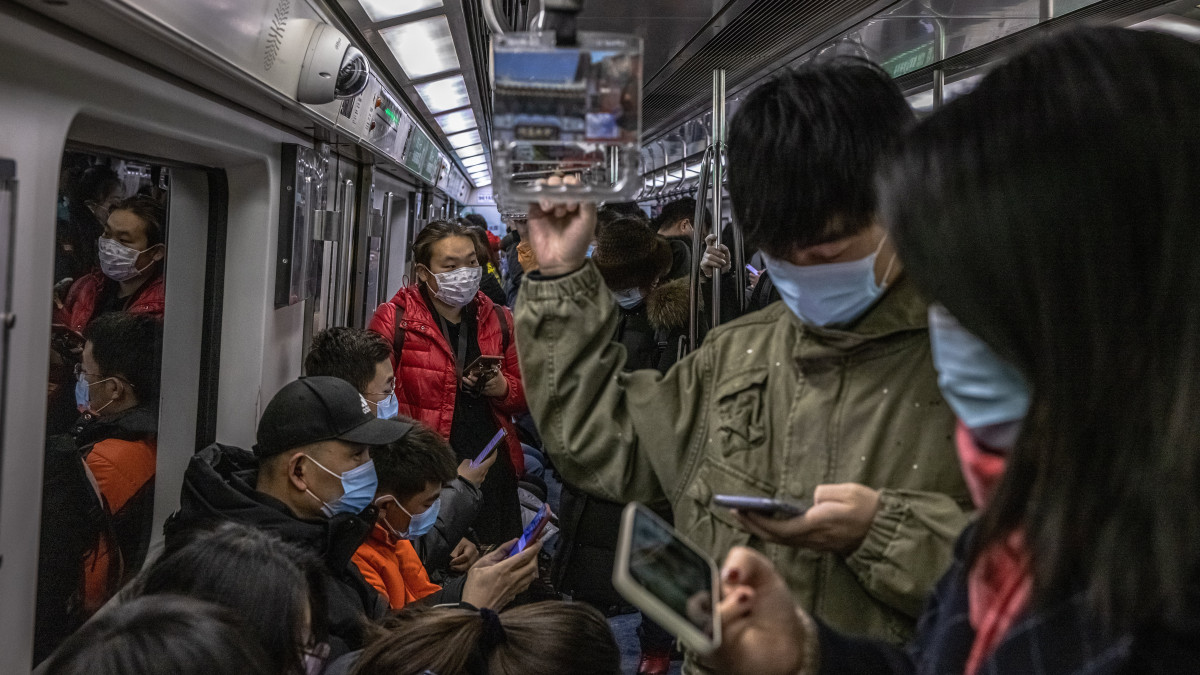 Védőmaszkos utasok egy pekingi metrón 2022. január 20-án. A kínai fővárosban január 15-én regisztrálták a koronavírus újabb változatával, az omikronnal fertőzött első esetet, és azóta emelkedik a fertőzöttek száma, hetekkel a 2022-es pekingi téli olimpia február 4-i kezdete előtt.