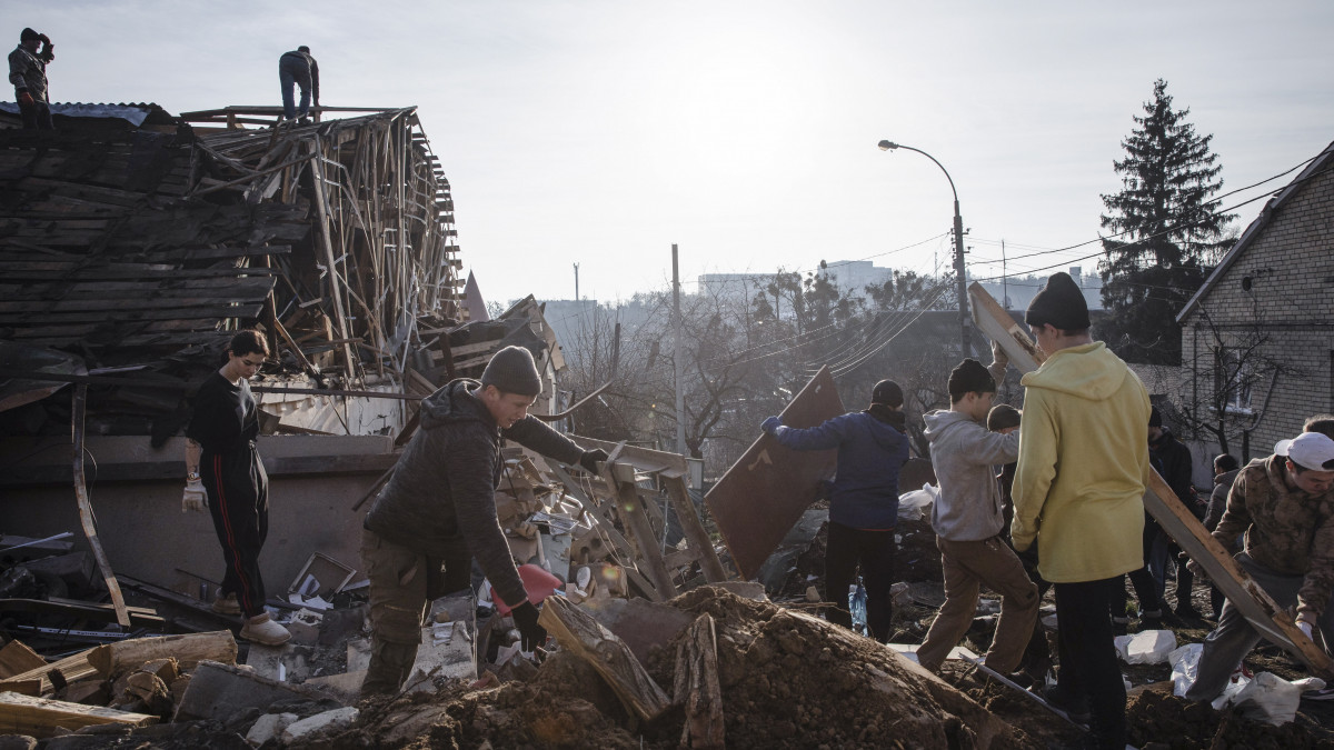 Önkéntesek takarítják a december 31-i orosz támadásban megsemmisült házak romjait Kijevben 2023. január 3-án.
