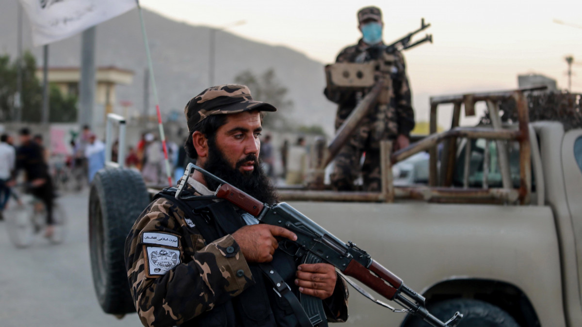 Tálib fegyveresek az Eid Gah mecset kapujánál, ahol ismeretlen elkövetők pokolgépet robbantottak 2021. október 3-án. Az imaházban Zabihullah Mudzsáhid, a tálib radikálisok eddigi szóvivője anyjának gyászszertartását tartották, amelyen állítólag több magas rangú tálib vezető is részt vett. A támadásban legkevesebb öt civil életét vesztette, többen megsebesültek. Afganisztánban augusztus 15-én kerültek újra hatalomra a radikális iszlamista tálib lázadók, akiket húsz évvel ezelőtt fosztott meg hatalmuktól az Egyesült Államok vezette nemzetközi katonai koalíció.