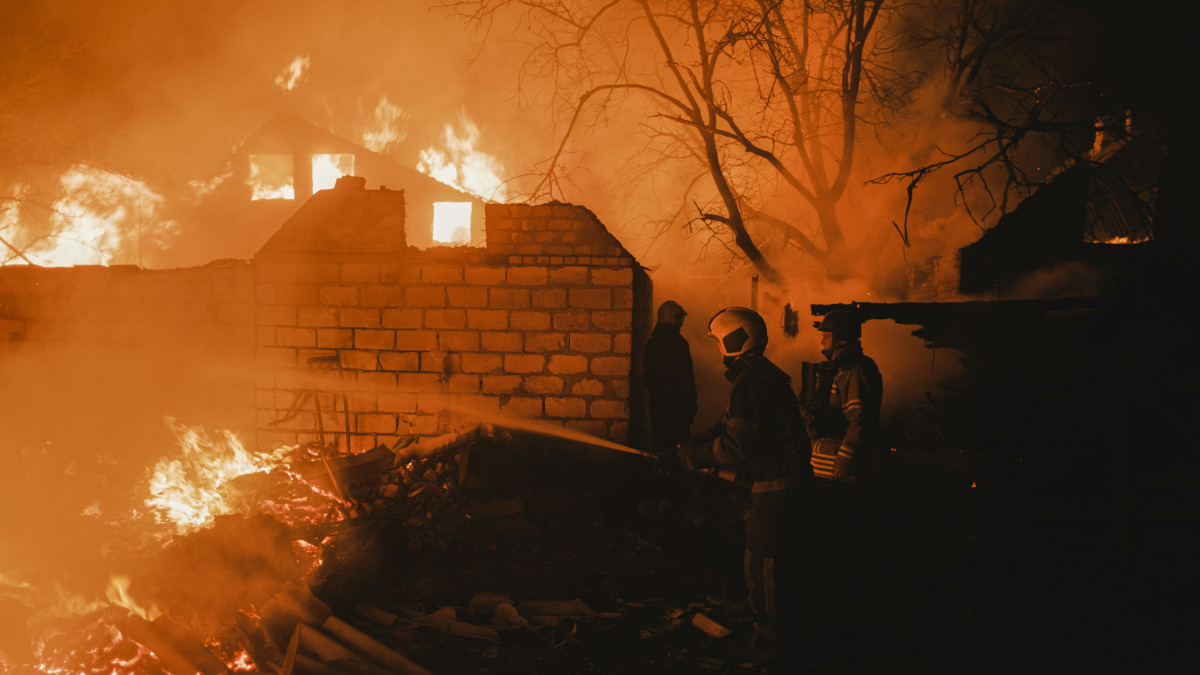 Orosz tüzérségi támadásban kigyulladt lakóház lángjait oltják a tűzoltók a kelet-ukrajnai Donyec-medencében levő Bahmut közelében 2023. január 2-án. Bahmut városában több mint négy hónapja dúló harcok miatt megszűnt az áram- és a gázszolgáltatás.