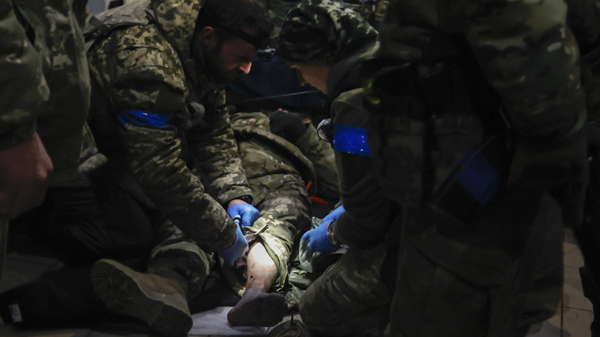 Ukrán katonák elsősegélyben részesítik sebesült bajtársukat egy óvóhelyen a kelet-ukrajnai Donyecki területen fekvő Szoledarban, ahol heves összecsapások zajlanak az ukrán és az orosz erők között 2023. január 8-án.