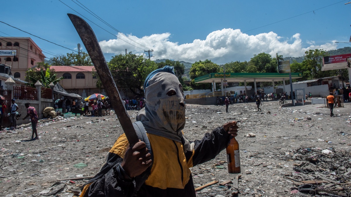 Kormányellenes tüntető bozótvágóval a kezében az Ariel Henry miniszterelnök lemondását követelő tiltakozáson a fővárosban, Port-au-Prince-ban 2022. szeptember 15-én. A karibi országban egy éven belül kétszeresére emelkedtek az üzemanyagárak, a lakosság 40 százaléka nem jut elegendő élelmiszerhez. A rendszeres zavargások miatt számos nagykövetséget bezártak.