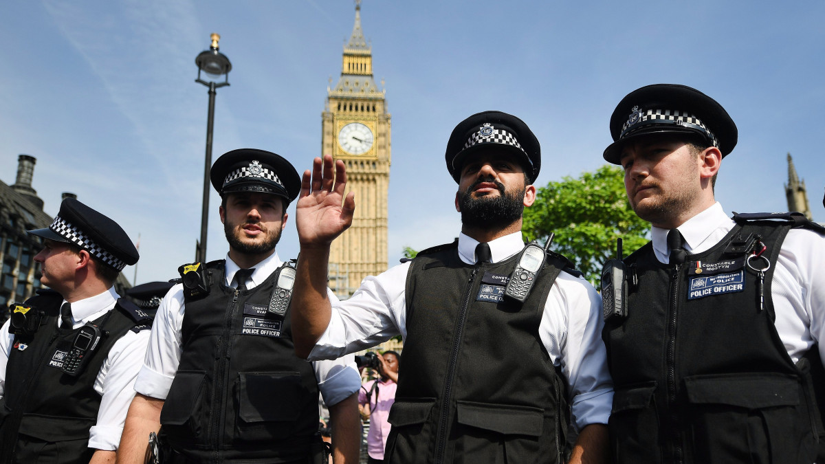 London, 2017. június 21. Rendőrök a londoni parlament előtt, ahol a nyugat-londoni Grenfell Tower toronyházat ért tűzvész károsultjai, az áldozatok hozzátartozói és szimpatizánsok tüntetnek magyarázatot követelve a történtekért 2017. június 21-én. Sajid Javid, önkormányzatokért és helyi közösségekért felelős brit miniszter bejelentette, hogy a kormány 68 lakást vett az érintettek kártérítésére egy új építésű lakónegyedben, a megsemmisült toronyház közelében. Az egy héttel korábban leégett, huszonnégy emeletes lakóházban hetvenkilencen vesztették életüket. A műszaki vizsgálat megkezdődött. (MTI/EPA/Andy Rain)