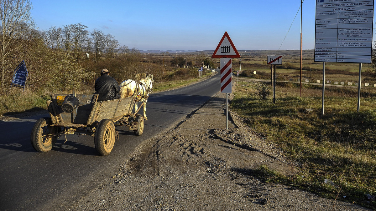 Az A3-as észak-erdélyi autópálya tájékoztató táblája mellett halad el egy lovaskocsi a partiumi Port településen 2016. november 11-én. A kivitelezői szerződés felbontását kérte a román közútkezelő társaságtól a pályaépítés feladatát 2015-ben elnyerő spanyol-román konzorcium, mert képtelenek teljesíteni a megbízást. A tervezési, építési feladatokat 24 hónap alatt kellett volna elvégezniük, de ez év szeptemberéig el sem kezdődött a munka.
