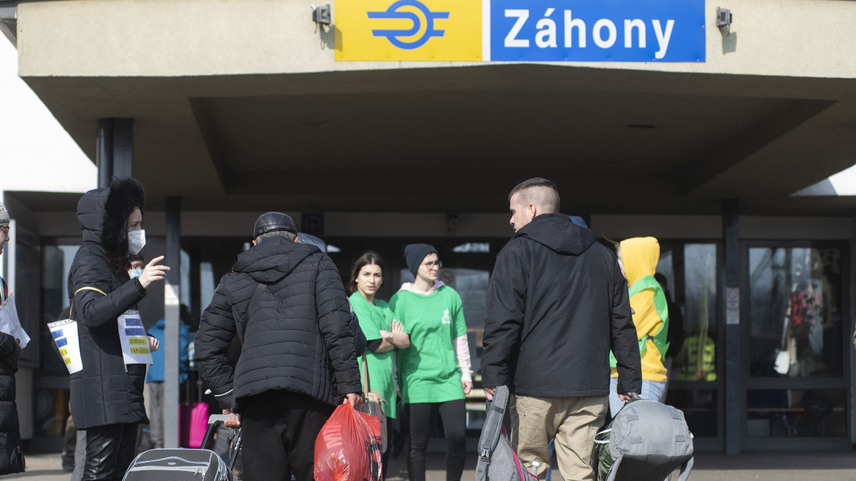 Az orosz-ukrán háború elől Ukrajnából menekülő embereknek segít egy önkéntes a záhonyi vasútállomáson 2022. március 7-én.