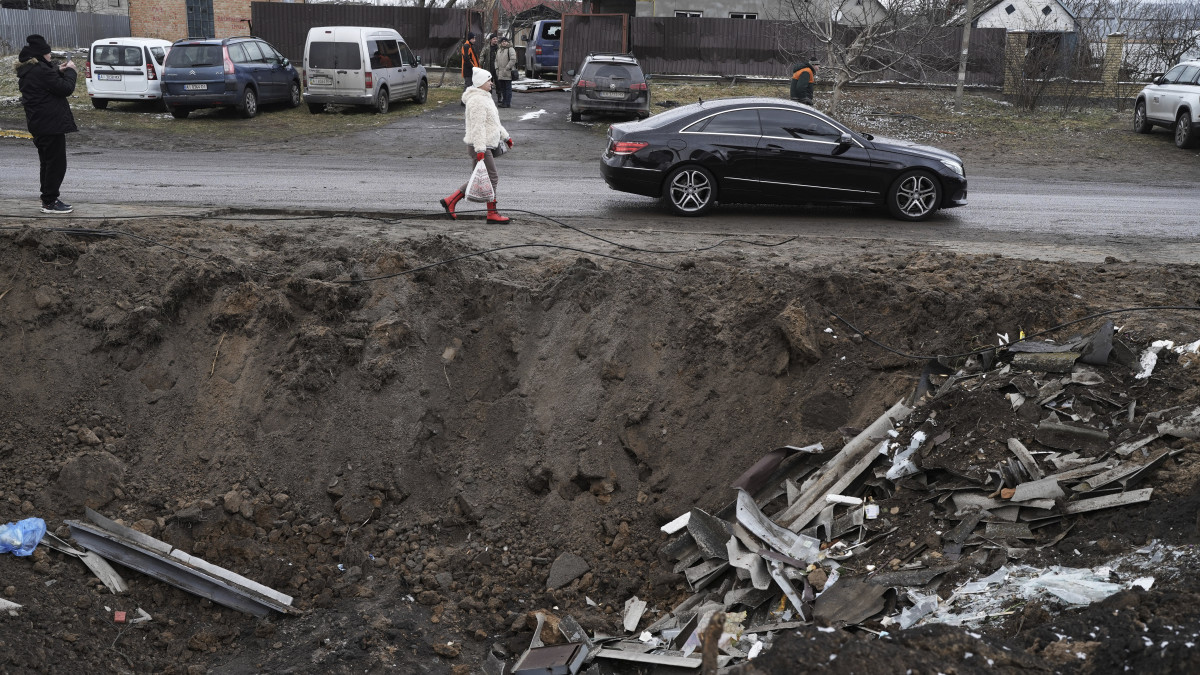 Orosz rakéta becsapódása nyomán keletkezett kráter mellett halad el egy autó a Kijev megyei Hlevakha településen 2023. január 26-án.