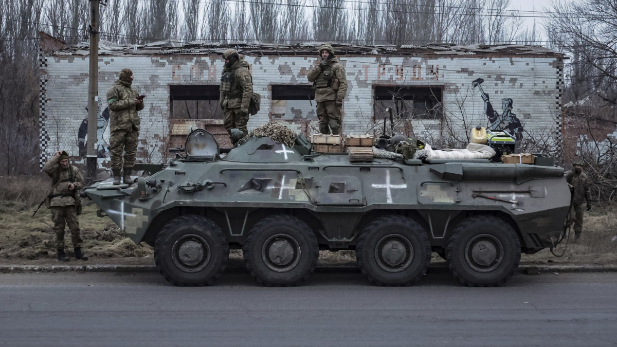 Ukrán katonák egy páncélozott jármű tetején állnak, mielőtt a frontra indulnak a kelet-ukrajnai Donyeck megyében 2023. január 28-án.