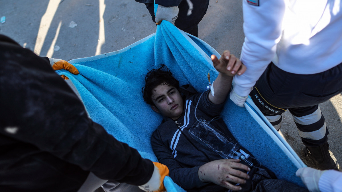 A romok alól kimentett fiút visznek hordágyon a földrengés sújtotta dél-törökországi Hatayban 2023. február 8-án. A fiú közel 60 órát töltött a romok alatt. Két nappal korábban több erős földrengés rázta meg Törökország délkeleti és Szíria északi részét, a legnagyobb rengés egyes mérések szerint a 7,8-as erősséget is elérte. A természeti katasztrófa halálos áldozatainak száma meghaladja a tizenegyezret.
