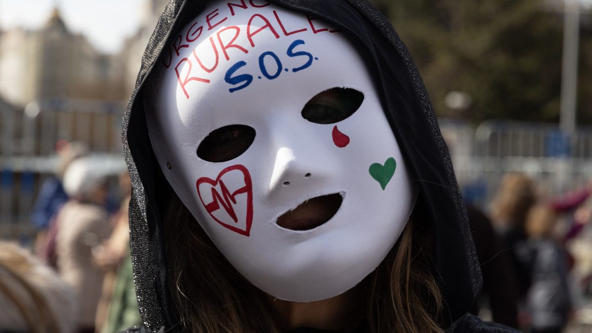 MADRID, SPAIN - FEBRUARY 12: A protestor wears a mask that reads Rural emergencies S.O.S. during a demonstration in support of the Public Health System on February 12, 2023 in Madrid, Spain. Tens of thousands of health workers held a similar protest in Madrid last month to decry what they say is the destruction of the public health system by the regional government. (Photo by Aldara Zarraoa/Getty Images)