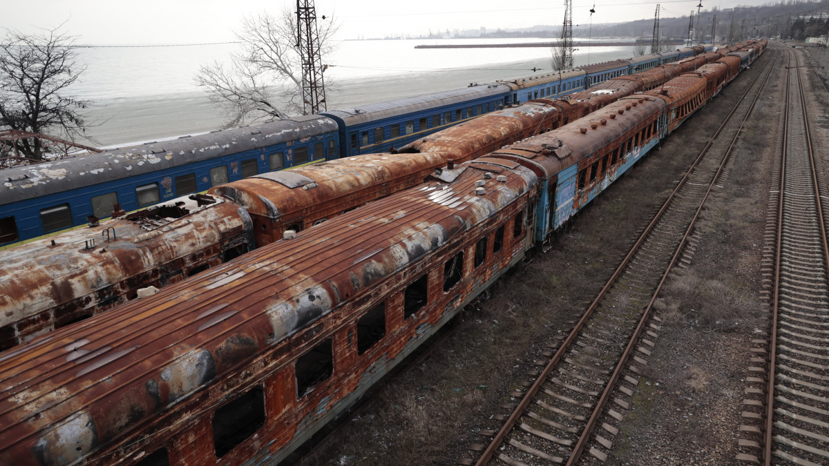 Kiégett vasúti kocsik állnak egy állomáson az Azovi-tenger partja közelében, a donyecki régió oroszok által ellenőrzött részén, a kelet-ukrajnai Mariupolban 2023. február 26-án.