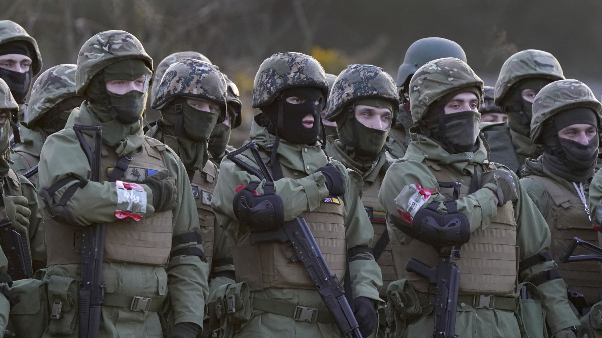 Ukrán katonák és a kiképzésüket irányító brit tisztek tisztelegnek az áldozatok előtt az Ukrajna elleni háború megindításának első évfordulója alkalmából tartott megemlékezésen a délkelet-angliai Lydd katonai támaszponton 2023. február 24-én.