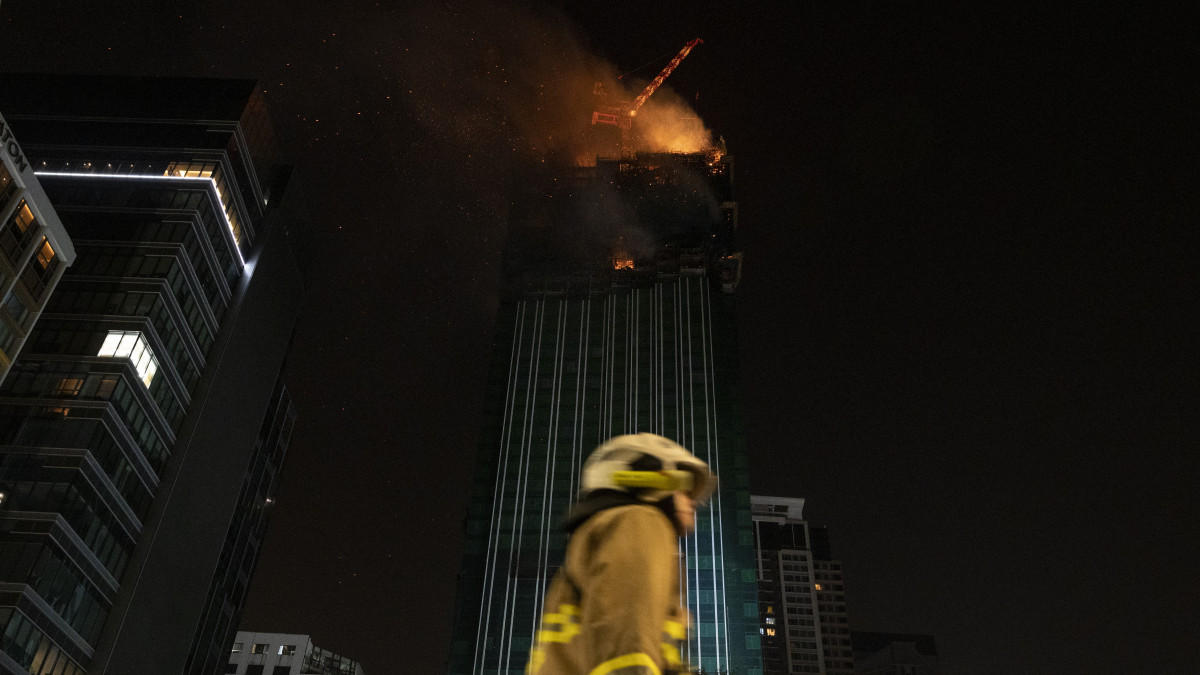 HONG KONG, CHINA - MARCH 3: A firefighter walks past the frame as a fire breaks out inside a building in Hong Kong, China on March 3, 2023. (Photo by Miguel Candela/Anadolu Agency via Getty Images)