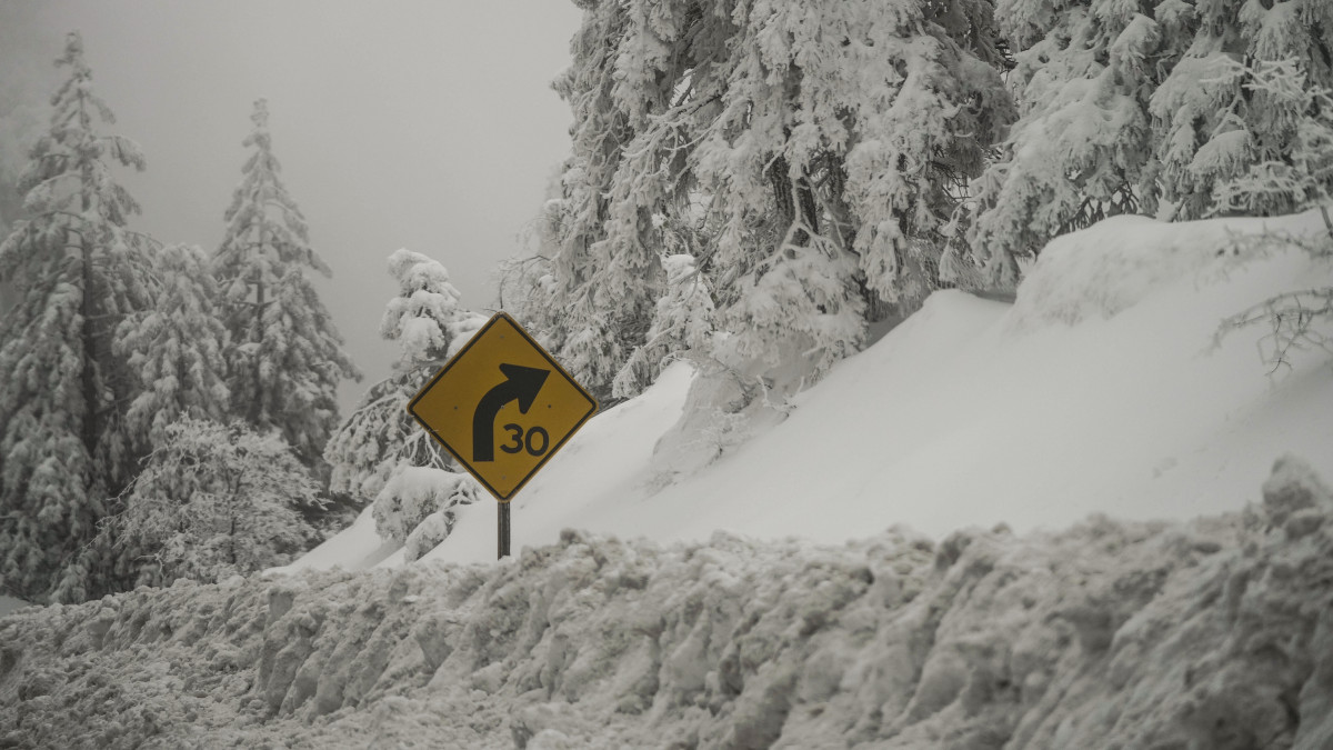 Vastag hóval betemetett útjelző tábla a kaliforniai Running Springs városban 2023. február 28-án. Kalifornia északkeleti részén a hatóságok a napokban figyelmeztetést adtak ki a Sierra Nevada hegységre lavinaveszély miatt, és újabb havazást várnak a február 24-én lehullott 60 centiméter után.