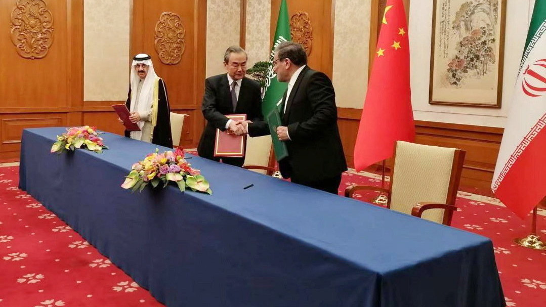 A Nournews iráni hírügynökség által közreadott képen Ali Samháni, az iráni nemzetbiztonsági tanács vezetője, Vang Ji kínai államtanácsos, a Kínai Kommunista Párt Központi Külügyi Bizottsága Főhivatalának igazgatója és Muszaid al-Aiban, Szaúd-Arábia nemzetbiztonsági tanácsadója (b-j) dokumentumot cserél, miután megállapodást írtak alá Pekingben 2023. március 10-én. Irán és Szaúd-Arábia a találkozót követően bejelentette, hogy helyreállítja diplomáciai kapcsolatait, a két ország külügyminiszterei nemsokára személyesen is egyeztetnek és a döntés értelmében Teherán és Rijád két hónapon belül újranyitja nagykövetségeit is.