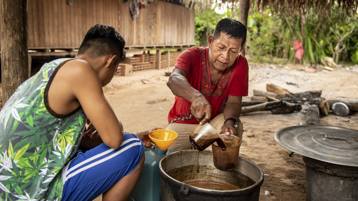 17 July 2018, Peru, Pucallpa: A shaman (R) puts a broth of Ayahuasca into a cup. The brew, which is prepared from the liana Banisteriopsis caapi, is used for medical or religious purposes in the Peruvian Shipibo ethnic group and in various Amazonian ethnic groups. Photo: Ana Karina Delgado/dpa (Photo by Ana Karina Delgado/picture alliance via Getty Images)