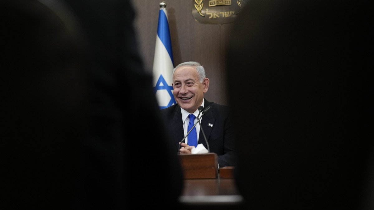 Benjámin Netanjahu izraeli miniszterelnök az új kormány eskütételi ünnepségét követő első kabinetülésen Jeruzsálemben 2022. december 29-én. Az izraeli parlamentben, a kneszetben a 120 képviselőből 63 szavazott bizalmat az új kormánynak, 54 ellenében. A kormánykoalíció a jobboldali Likud párt, a szélsőségesen jobboldali Vallásos Cionisták nevű telepespárt, az ultranacionalista Zsidó Erő (Ocma Jehudit) párt, valamint az európai eredetű ultraortodox askenázik Egyesült Tórapártjából és a keleti ultraortodoxok Sasz pártjából áll.