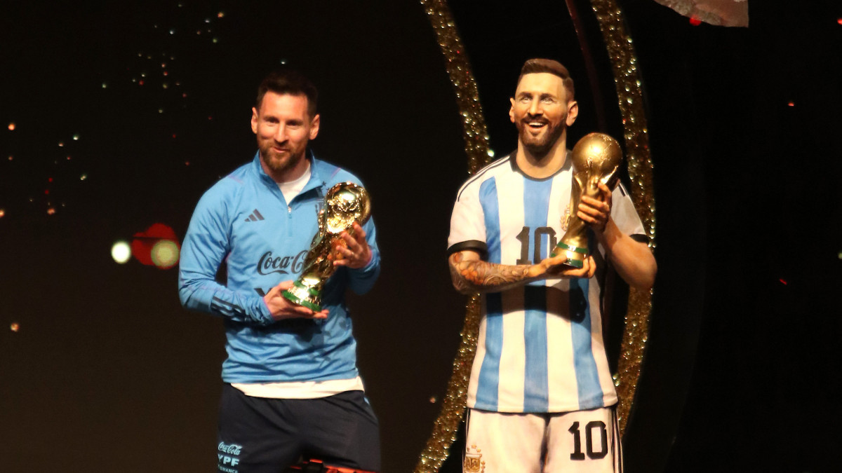 ASUNCION, PARAGUAY - MARCH 27: Lionel Messi of Argentina poses with the FIFA World Cup trophy next to a statue of himself during an event organized by CONMEBOL at their headquarters to pay tribute to the last FIFA World Cup Champions on March 27, 2023 in Asuncion, Paraguay. (Photo by Christian Alvarenga/Getty Images)