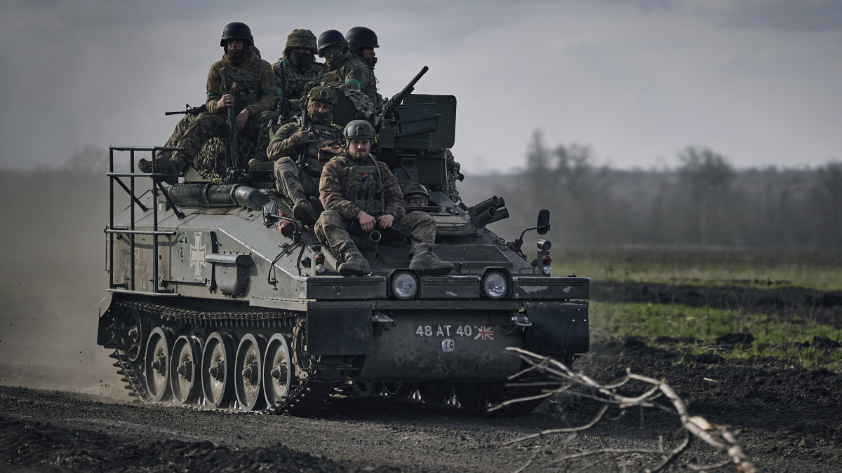 Ukrán katonák egy páncélozott személyszállító harcjárművön a donyecki régióban fekvő, ostromgyűrűben lévő Bahmutban 2023. március 25-én. Bahmutot az ukrán védelmi erők tartják ellenőrzésük alatt, míg az orosz egységek erőiket a környező települések irányában történő támadó műveletek végrehajtására összpontosítják.