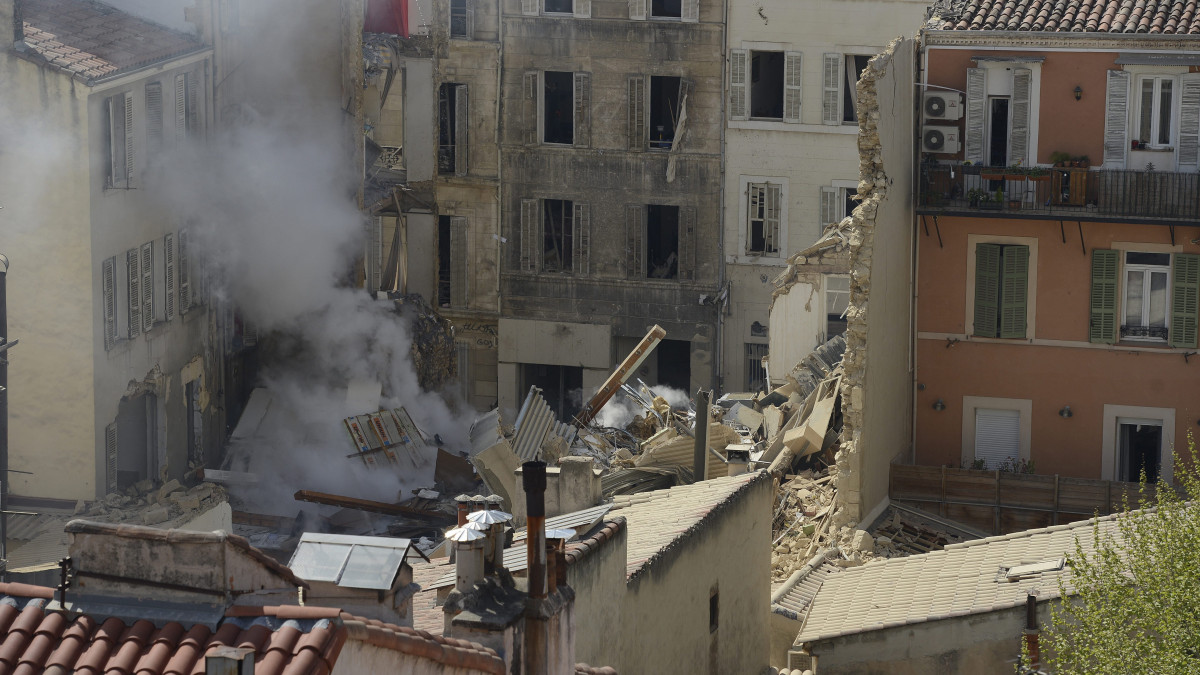 Füstölgő romok a helyszínen 2023. április 9-én, miután feltehetőleg robbanás következtében összedőlt egy lakóház a dél-franciaországi kikötővárosban, Marseille-ben. Legalábbb öt ember megsérült, és a belügyminiszter szerint még négy-tíz ember lehet a romok alatt, ahol tűz is keletkezett.