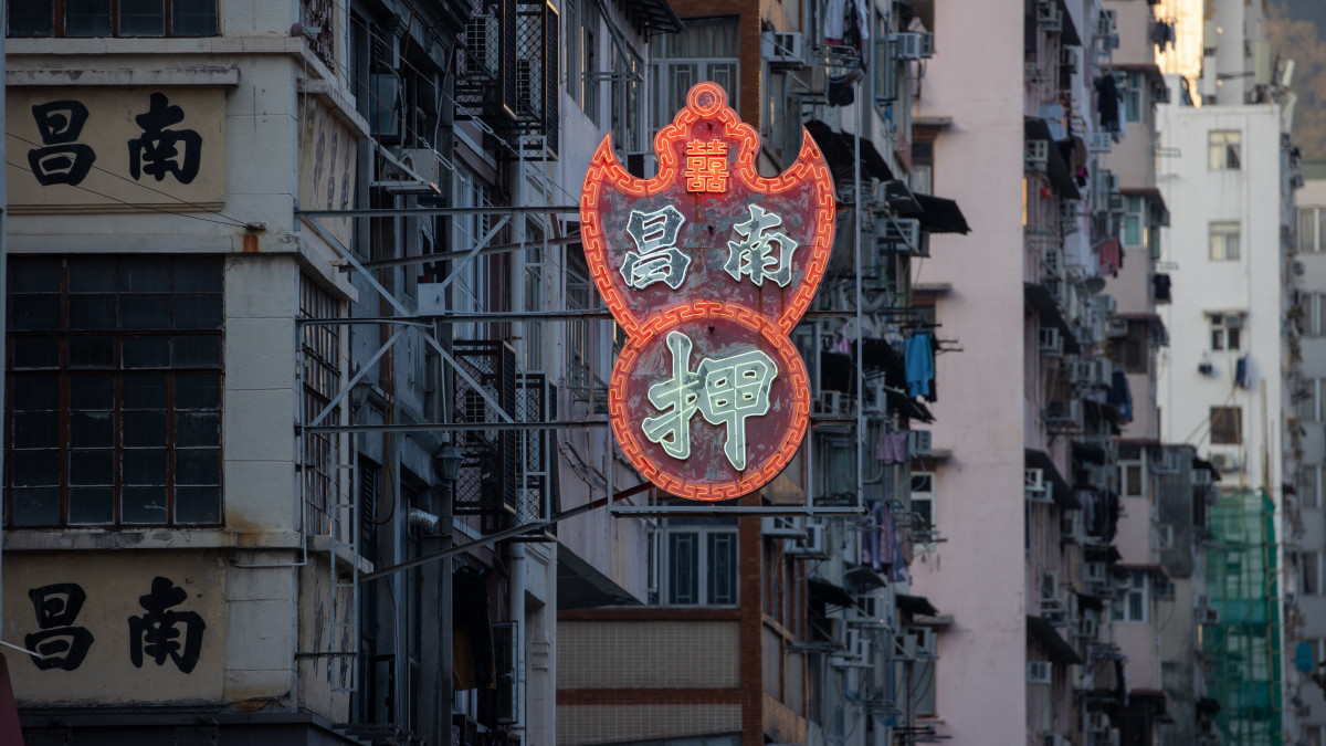 2023. január 30-i kép a Nam Cheong zálogház fénycégéreiről az üzlethelyiség épületén, Hongkong Sham Shui Po negyedében. A neondísz pénzérmét hordozó, széttárt szárnyú denevért ábrázol, a denevér pedig a jólét jelképe a kínai kultúrában. Az utóbbi évtizedben a városvezetés az új biztonsági és környezetvédelmi előírásokkal összhangban eltávolíttatta a Hongkong jellegzetes városképét adó neonreklámok zömét. Hivatalos adatok szerint Hongkongban 2016-ban még körülbelül 120 ezer fénycégér világított, többségük azonban nem felelt meg az előírásoknak. Becsült számuk 2023-ra mindössze félezerre zsugorodott.