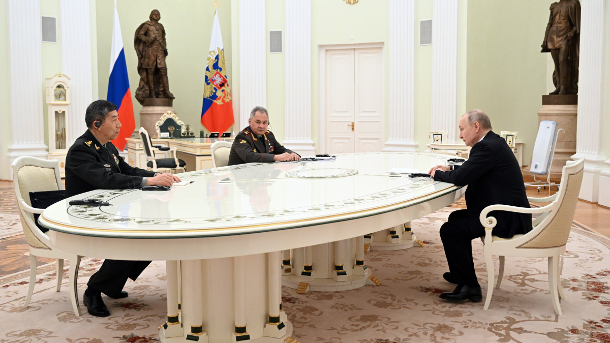 Vlagyimir Putyin orosz elnök (j) a hivatalos látogatáson Oroszországban tartózkodó Li Sang-fu kínai védelmi minisztert (b) fogadja Szergej Sojgu orosz védelmi miniszter (k) jelenlétében a moszkvai Kremlben 2023. április 16-án.