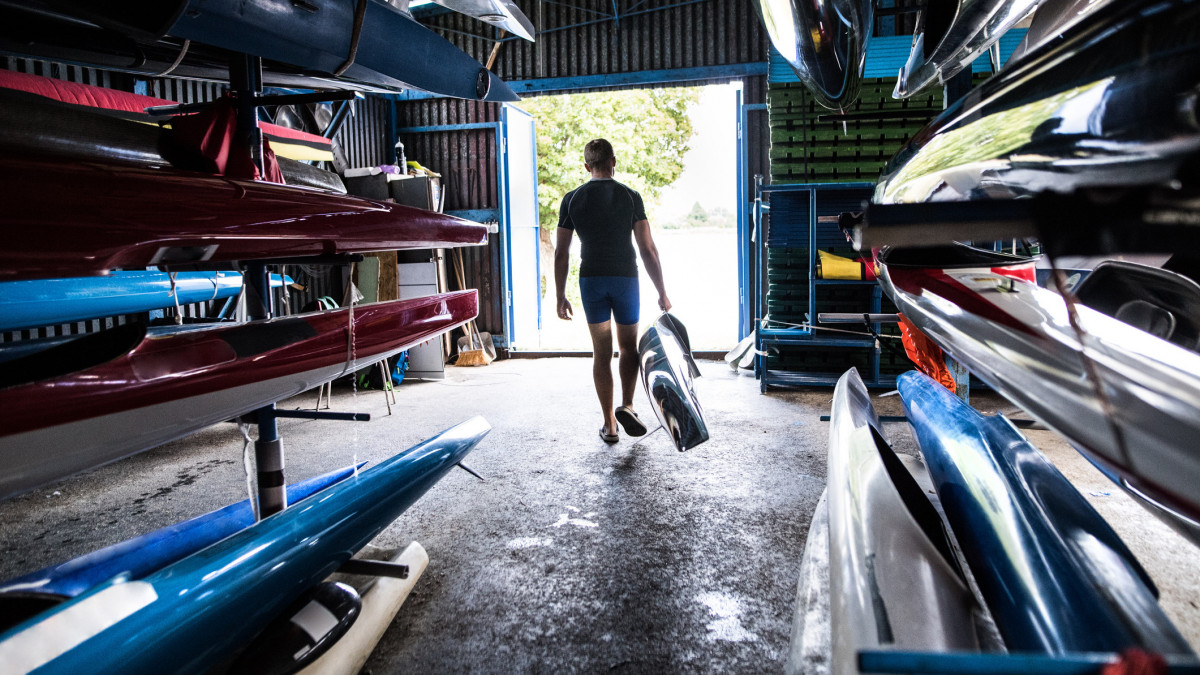 Young man in a kayak and canoe storage room. Speed canoeing.