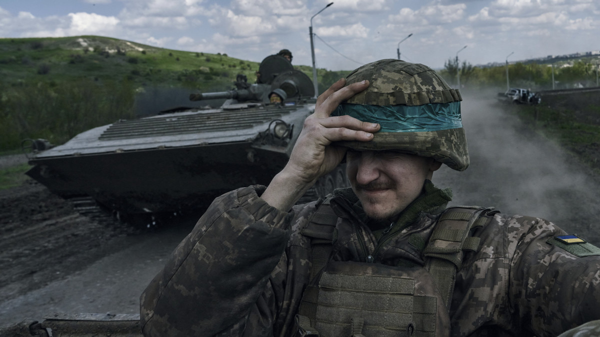 Ukrán katona páncélozott harcjárművön az orosz erők által ostromlott kelet-ukrajnai Bahmutban 2023. április 26-án.