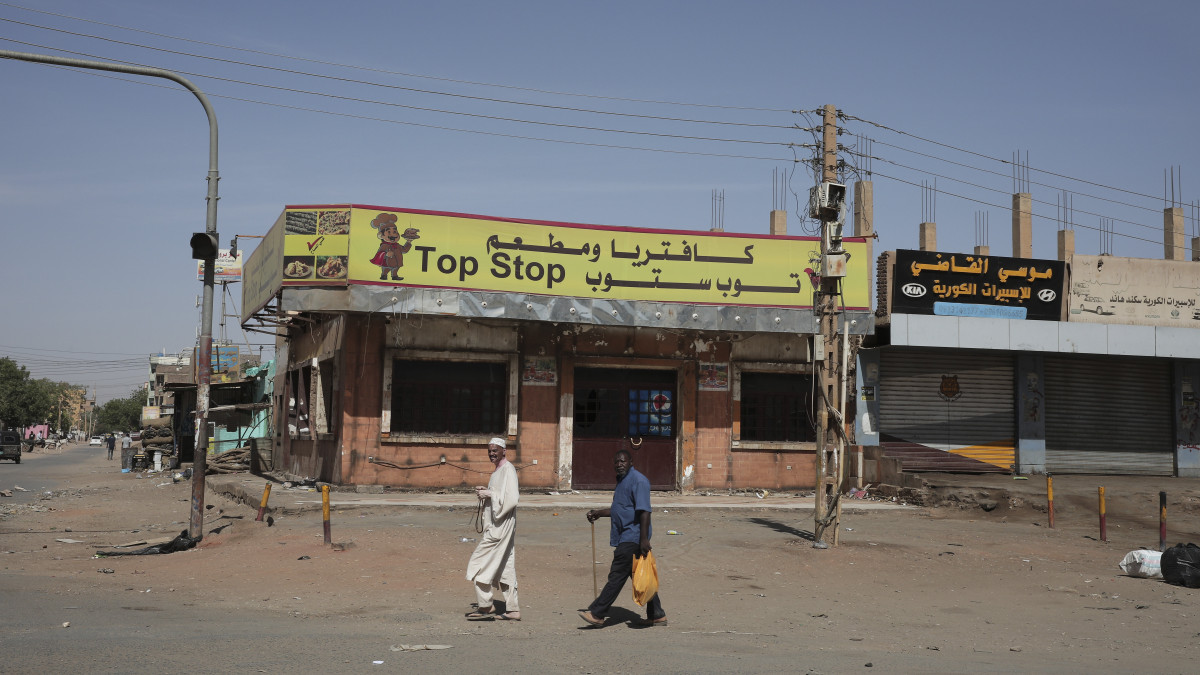 Bezárt boltok előtt mennek emberek a szudáni főváros, Kartúm egyik negyedében 2023. április 18-án, három nappal azután, hogy harcok robbantak ki Abdel-Fattah Burháni tábornoknak, a szudáni átmeneti kormányzó Szuverén Tanács vezetőjének a riválisa, Mohamed Hamdan Daglo tábornok vezette Félkatonai Gyors Támogató Erők (RSF) és a hadsereg között. Az összecsapásokban eddig legkevesebb 180-an életüket vesztették és 1800-an megsebesültek.