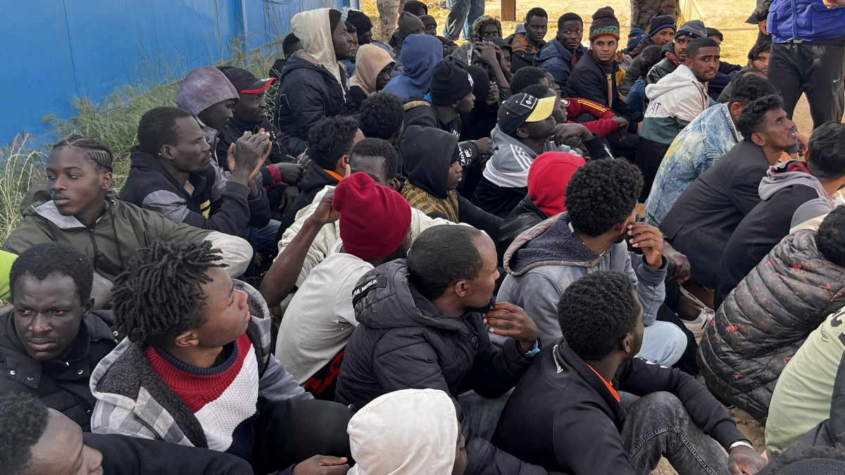 A líbiai parti őrség által partra szállított illegális bevándorlók várakoznak a fővárostól, Tripolitól keletre fekvő Garaboli kikötőjében 2023. április 25-én, miután két, migránsokat szállító csónak elsüllyedt a Földközi-tengeren. A Líbiai Vörös Félhold segélyszervezet szerint eddig tizenegy partra mosott holttestet találtak a Tripolitól nyugatra levő Szabratha város partjainál.MTI/EPA/STRINGER