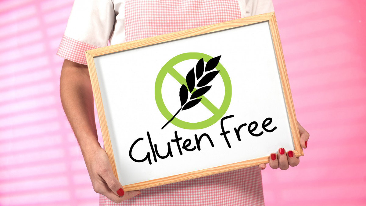 woman holding a sign indicating gluten free food available