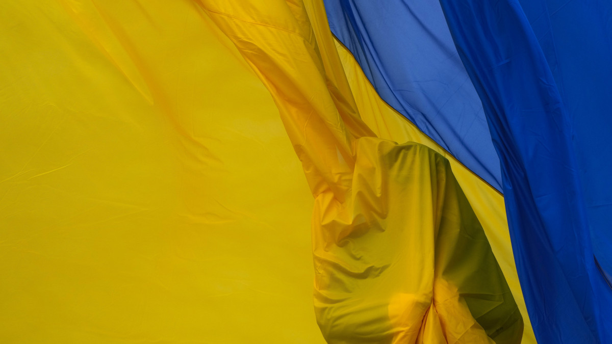 Felvonják az ukrán zászlót a Kijev közelében fekvő Bucsában tartott megemlékezésen 2023. március 31-én. Egy évvel ezelőtt ezen a napon szabadították fel az ukrán csapatok Bucsát, ahol az orosz katonák mészárlást követtek el civilekkel szemben, a helyi hatóságok adatai szerint 458 embert öltek meg. Oroszország tagadja a vádakat. A mészárlás ügyében jelenleg nemzetközi vizsgálat zajlik.