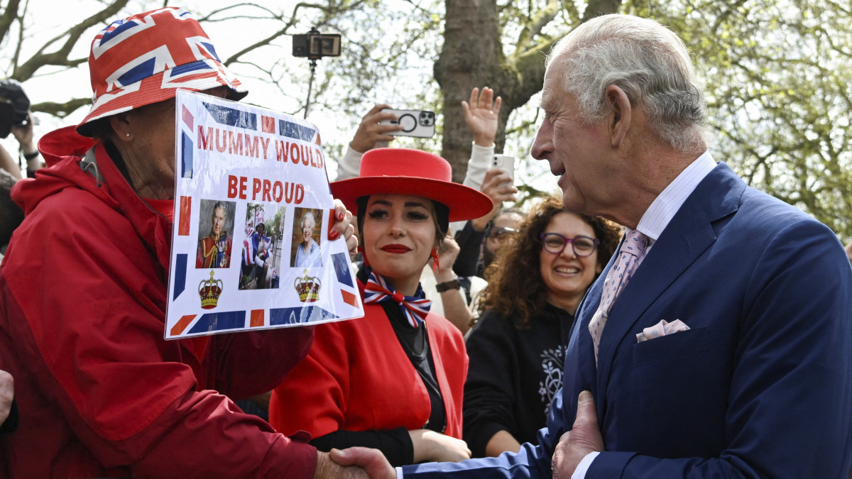 III. Károly brit király beszélget az emberekkel, miközben megnézi az ünnepi előkészületeket a londoni Buckingham-palota előtt 2023. május 5-én. III. Károlyt május 6-án koronázzák meg a londoni Westminster-apátságban.