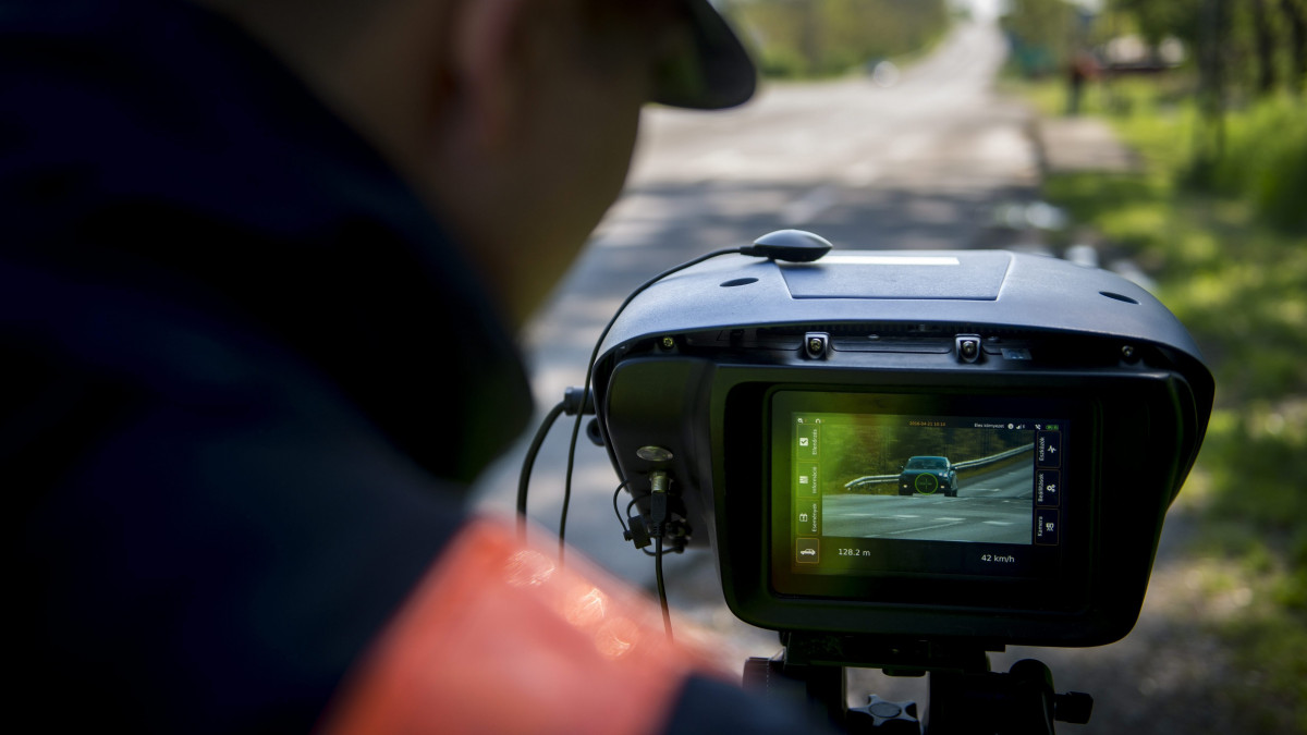 Egy rendőr a Véda automata közlekedés-ellenőrzési rendszer egyik sebességmérőjével a 6-os főúton, Pécs határában 2016. április 21-én. Csaknem kilencszáz magyarországi helyszínen ellenőrzi a rendőrség a sebességhatár túllépését reggel hat óra óta 24 órán keresztül a Speedmarathon nemzetközi akció keretében.