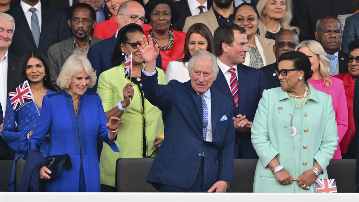 III. Károly brit király integet a felesége, Kamilla királyné (b) társaságában a koronázását ünneplő rendezvénysorozat záróeseményeképp tartott szuperkoncerten az angliai Windsorban 2023. május 7-én, a koronázás másnapján. A világsztárokat felvonultató koncertet a legnagyobb és legősibb brit királyi rezidencia, a London nyugati határában emelkedő windsori kastély parkjában tartották a királyi család és húszezer néző jelenlétében.