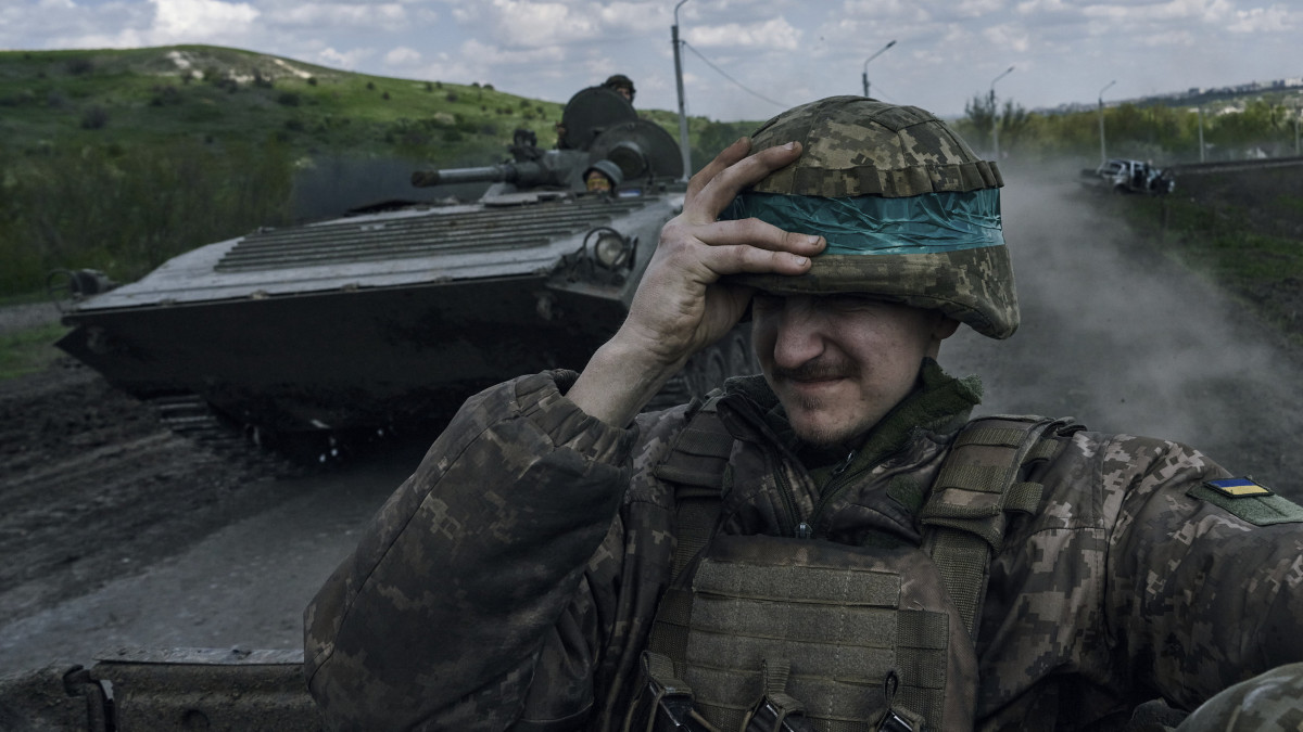 Ukrán katona páncélozott harcjárművön az orosz erők által ostromlott kelet-ukrajnai Bahmutban 2023. április 26-án.