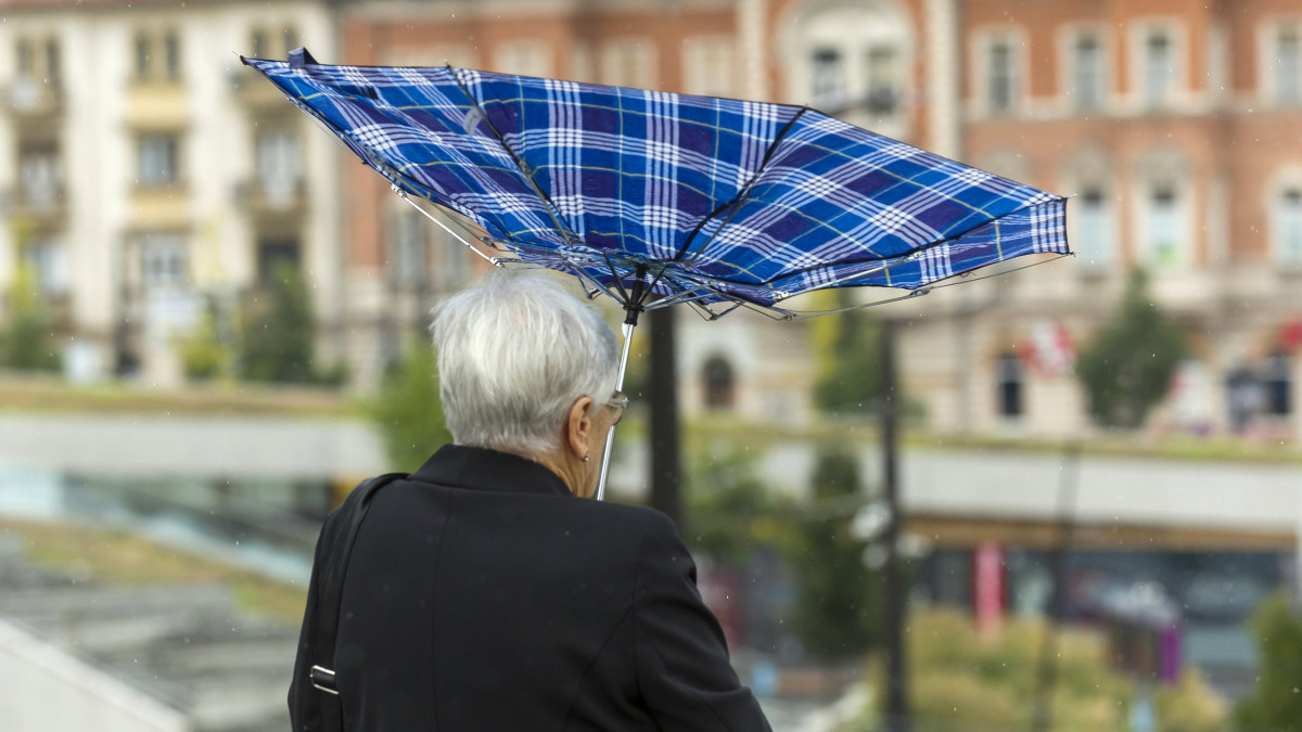 A szél kifordítja egy nő esernyőjét a Széll Kálmán téren 2018. augusztus 26-án.