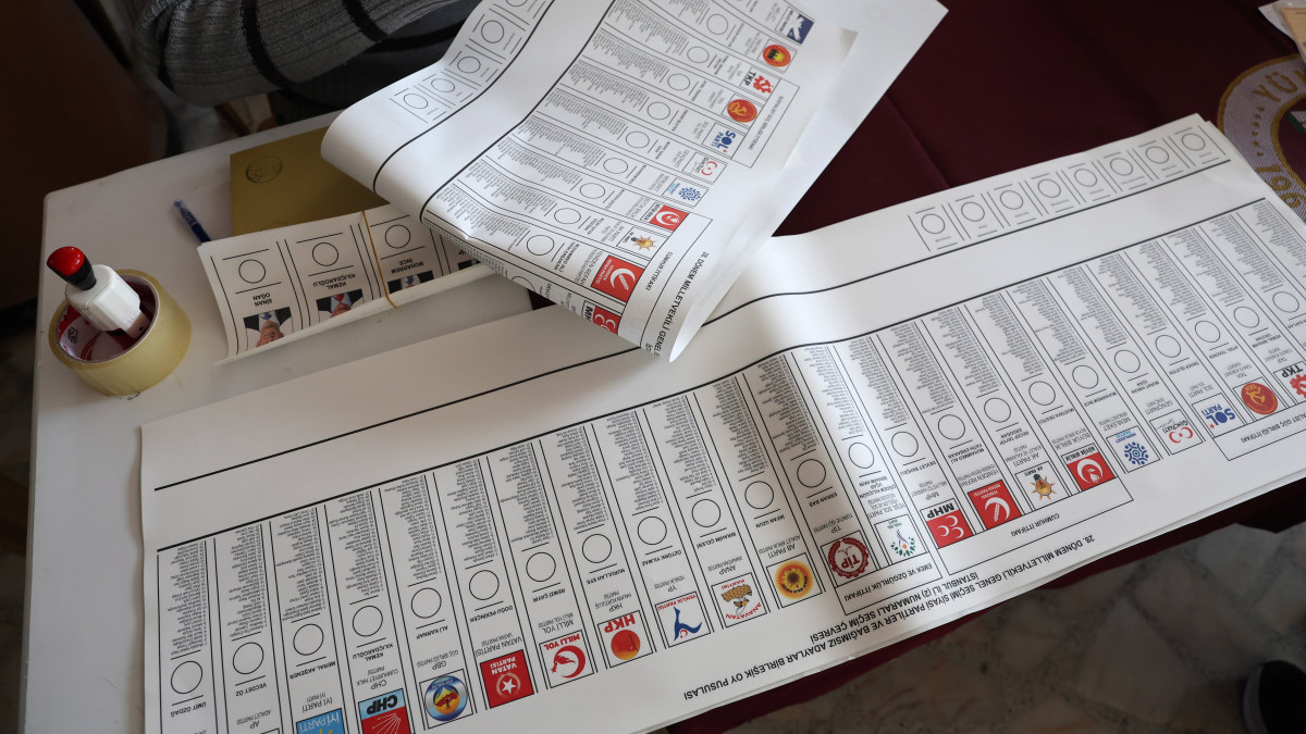Szavazólapot fog egy választási biztos egy isztambuli szavazóhelyiségben 2023. május 14-én, a török elnökválasztás első fordulójának napján. Törökországban május 14-én parlamenti választásokat is tartanak.