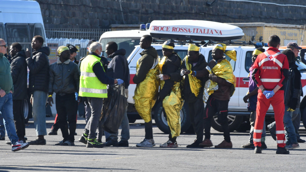 Lampedusa szigetéről átszállított illegális bevándorlók szállnak le az olasz haditengerészet Vega hajójáról a szicíliai Catania kikötőjében 2023. április 27-én. A mintegy ötszáz migránst szállító hajóról az emberek felét engedik le Cataniában, a másik felét egy közeli kikötőn kersztül a szicíliai San Giuseppe La Rena fogadóközpontjában helyezik el. Az előző napon összesen 1078 migráns érkezett a már elelve túlzsúfolt lampedusai regisztrációs központba.