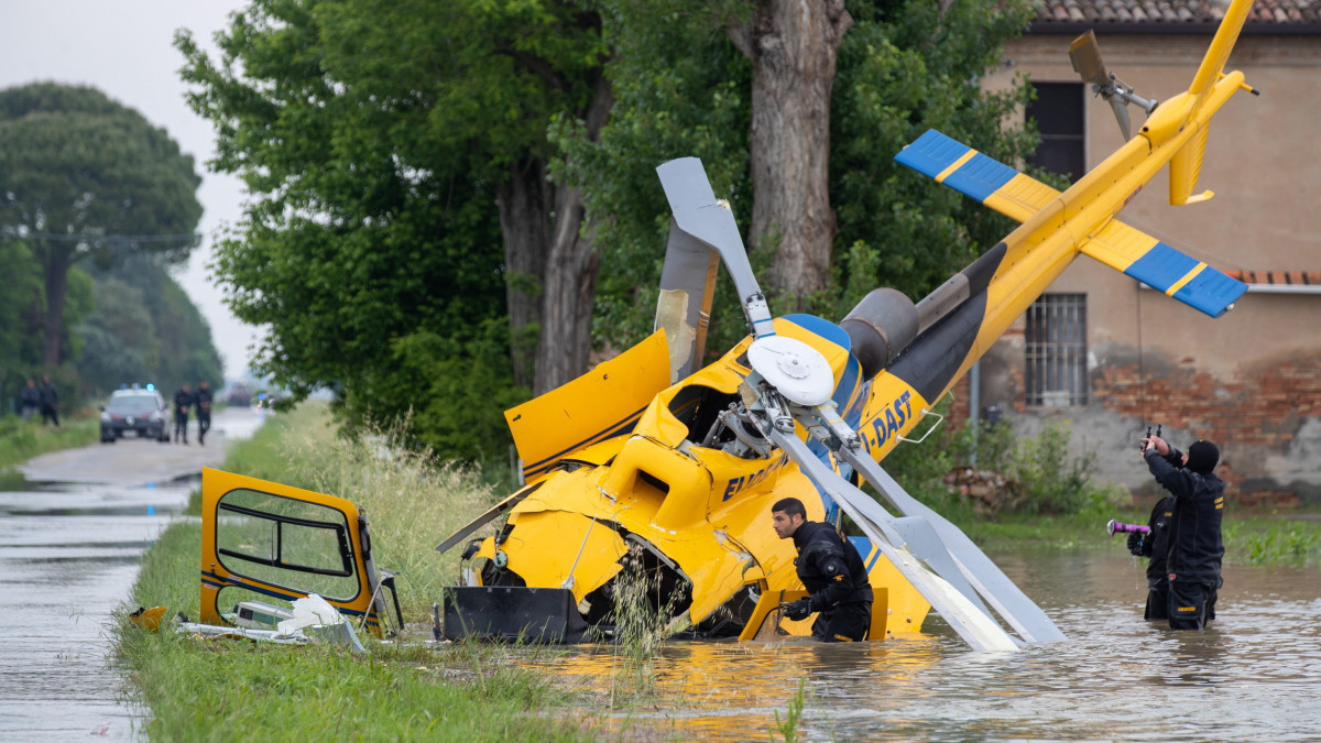 Mentőalakulatok tagjai vizsgálják a lezuhant mentőhelikopter roncsát a Ravenna tartományban fekvő Belricettóban 2023. május 20-án. A fedélzeten lévő mind a négy embert kórházba vitték, de csak az egyikük sérült meg. Emilia-Romagna tartományban a folyók, patakok áradása és az esőzés okozta földcsuszamlások miatt a legmagasabb fokozatú készültség van érvényben továbbra is. Az Olaszországot sújtó esőzések halálos áldozatainak száma 14-re emelkedett.