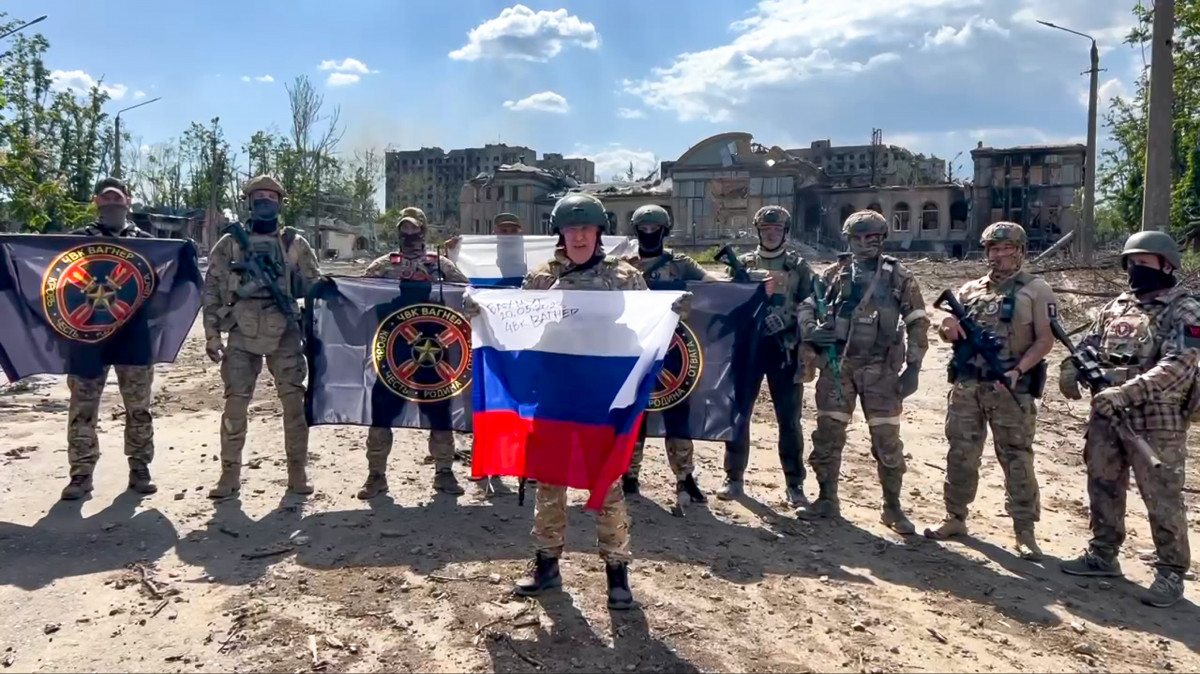Jevgenyij Prigozsin sajtószolgálata által közreadott, videófelvételről készített kép Prigozsinról, a Wagner orosz magánhadsereg alapítójáról (k) egy orosz zászlóval a kezében és a katonáiról Bahmutban 2023. május 20-án. Prigozsin a nap folyamán bejelentette, hogy teljesen sikerült ellenőrzésük alá vonni a kelet-ukrajnai várost, de az ukrán hadsereg ezt tagadja.